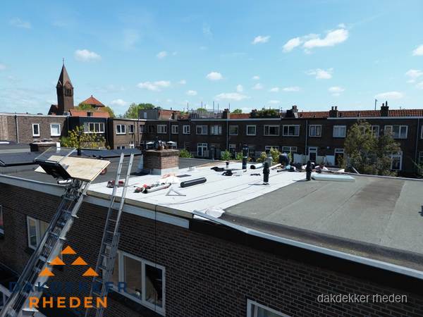 Dakdekkers aan het werk op plat dak in Rheden
