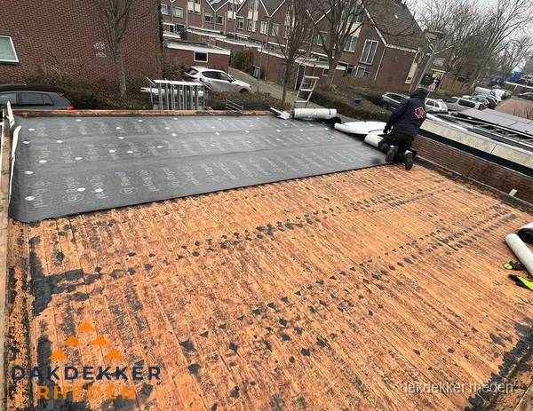 Dakdekker legt onderlaag op plat dak met houten constructie in Rheden