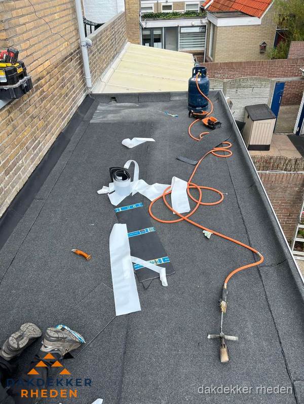 Dakdekkers bezig met bitumen dakbedekking in Rheden