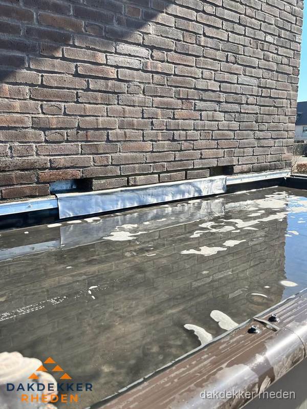 Stilstaand water op plat dak door slechte afwatering in Rheden Stilstaand water op plat dak door slechte afwatering in Rheden
