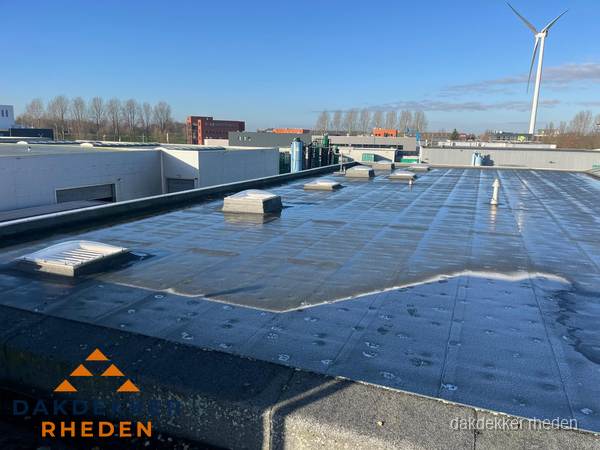 Plat dak bedrijfspand met bitumen dakbedekking en lichtkoepels in Rheden