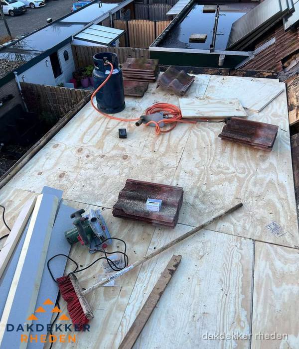 Dakreparatie werkzaamheden op plat dak met gereedschap in Rheden