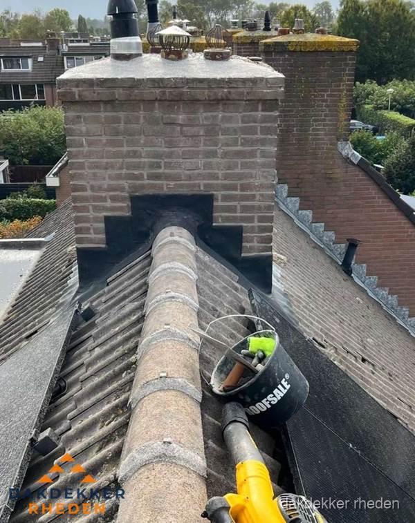 Schoorsteen met loodaansluiting en nokvorst op pannendak in Rheden