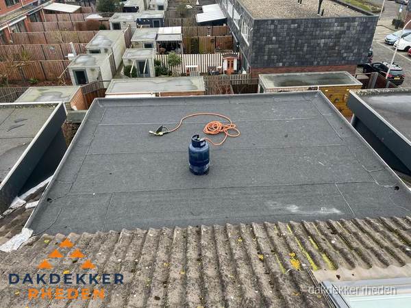 Plat dak met nieuwe bitumen dakbedekking en brandgereedschap in Rheden