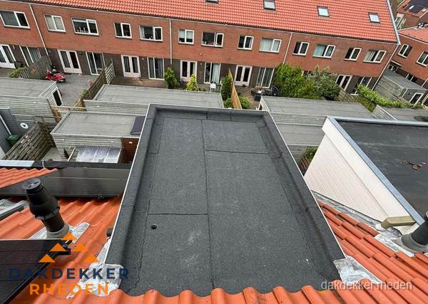 Plat dak met bitumen bedekking naast dakkapel in Rheden