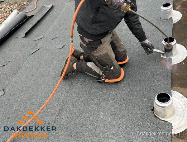 Dakdekker repareert bitumen dakleer bij dakdoorvoer in Rheden