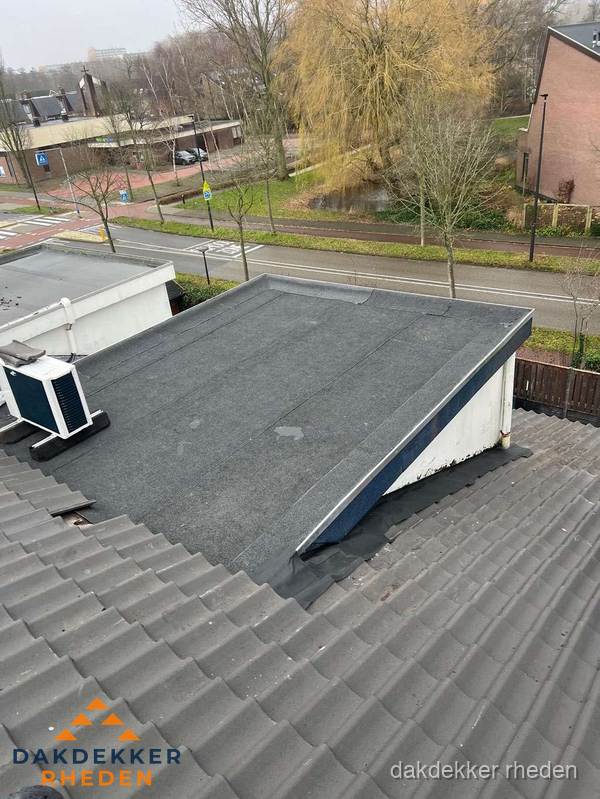 Plat dak met bitumen dakbedekking naast schuin pannendak in Rheden